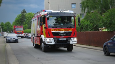 Fire trucks on the road during the day the red and white
